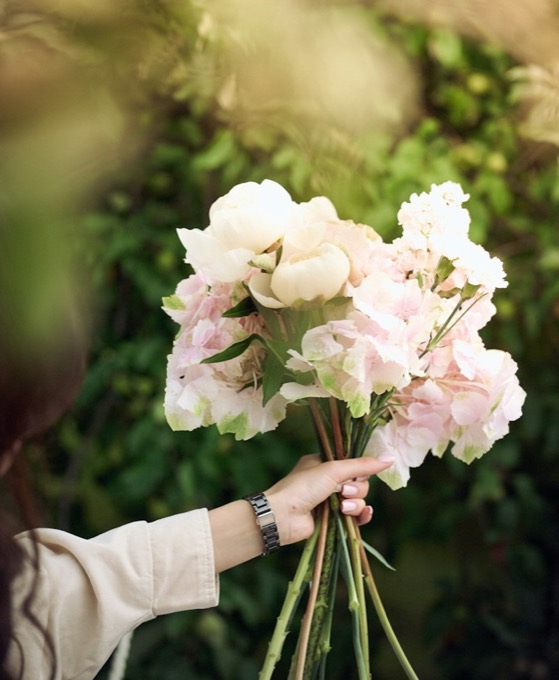 白とピンクの花束を持つ手